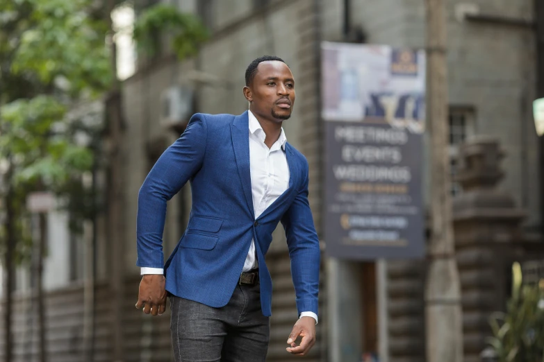 a man in a suit walks down a city street