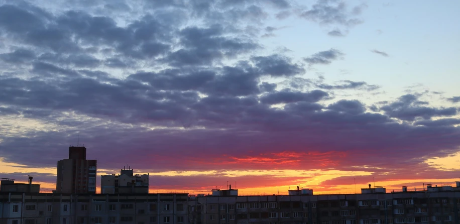 a sunset view from a distance with buildings in the background