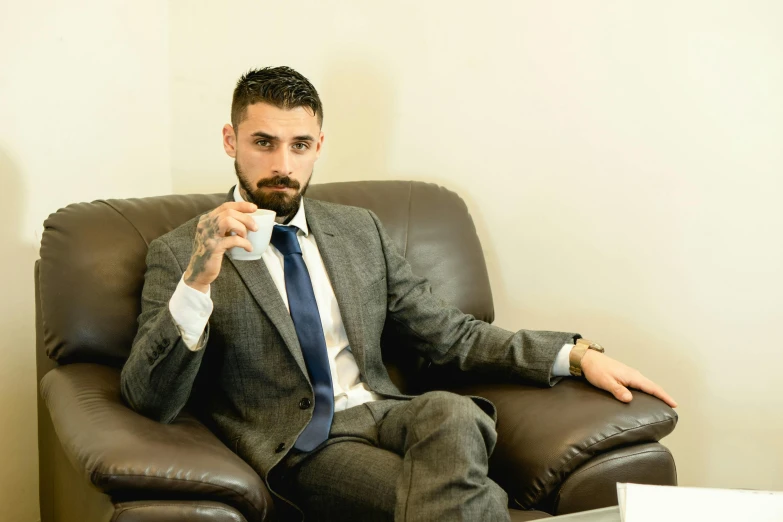 a man sitting in an office chair wearing a suit and tie