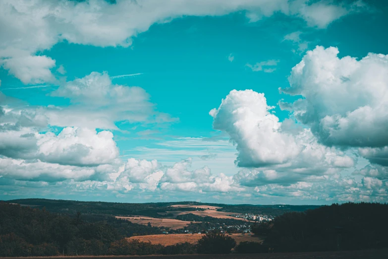 a large blue and white sky is above some trees