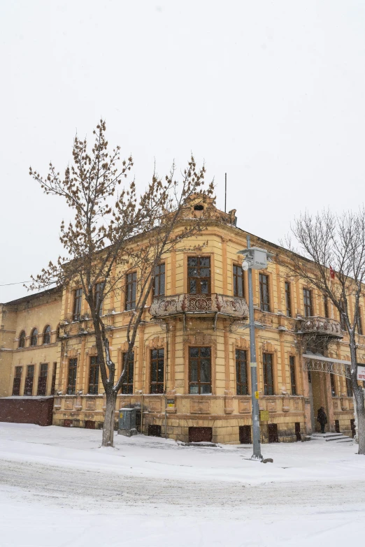 a large yellow building is in the snow