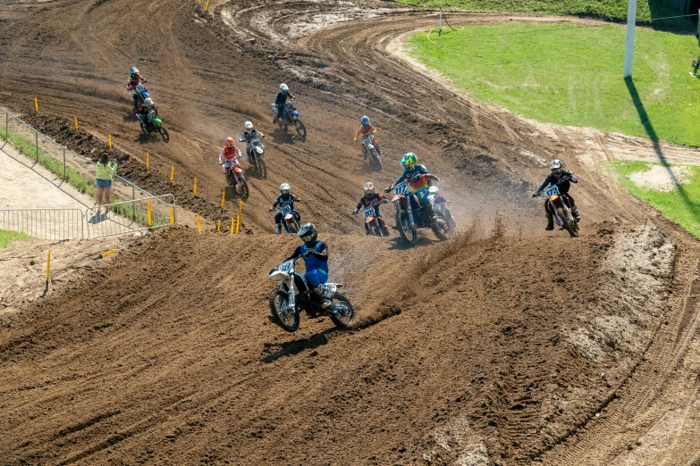 a group of people on dirt bikes ride along the track