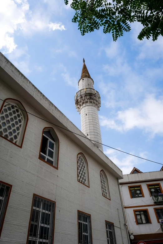 a white building with many windows and a light tower in the background