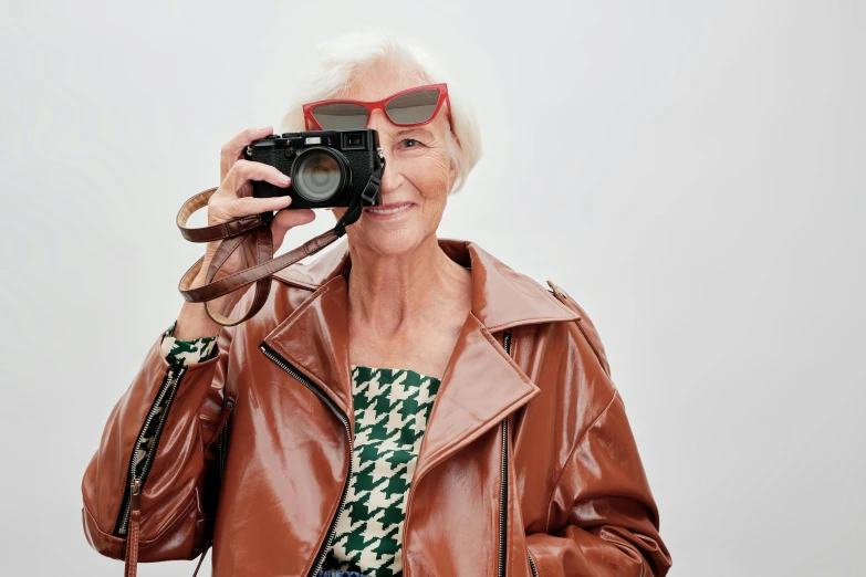 a woman in glasses holding a camera and taking a picture