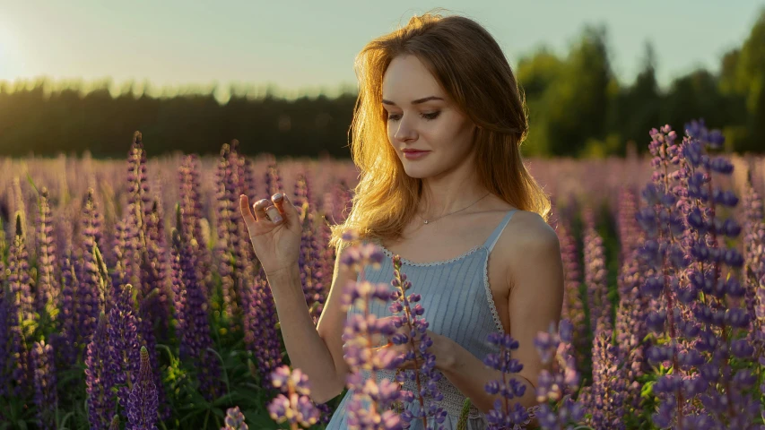 a woman standing in a field of purple flowers