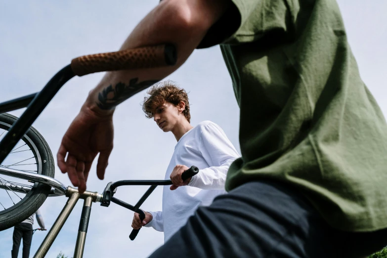 a man with a tattoo on his arm putting a bike on a ramp