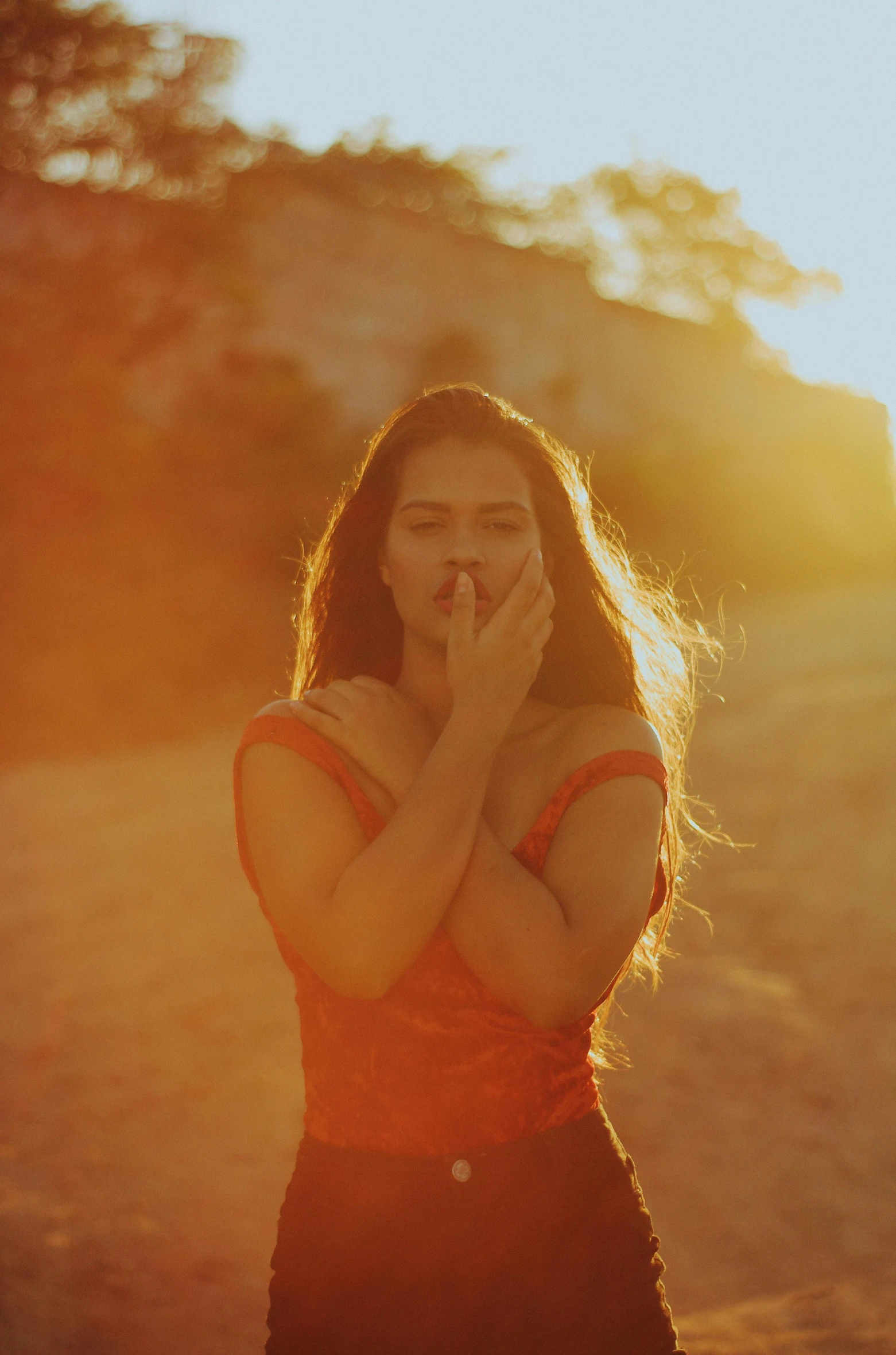 a woman wearing a dress covers her mouth with hands