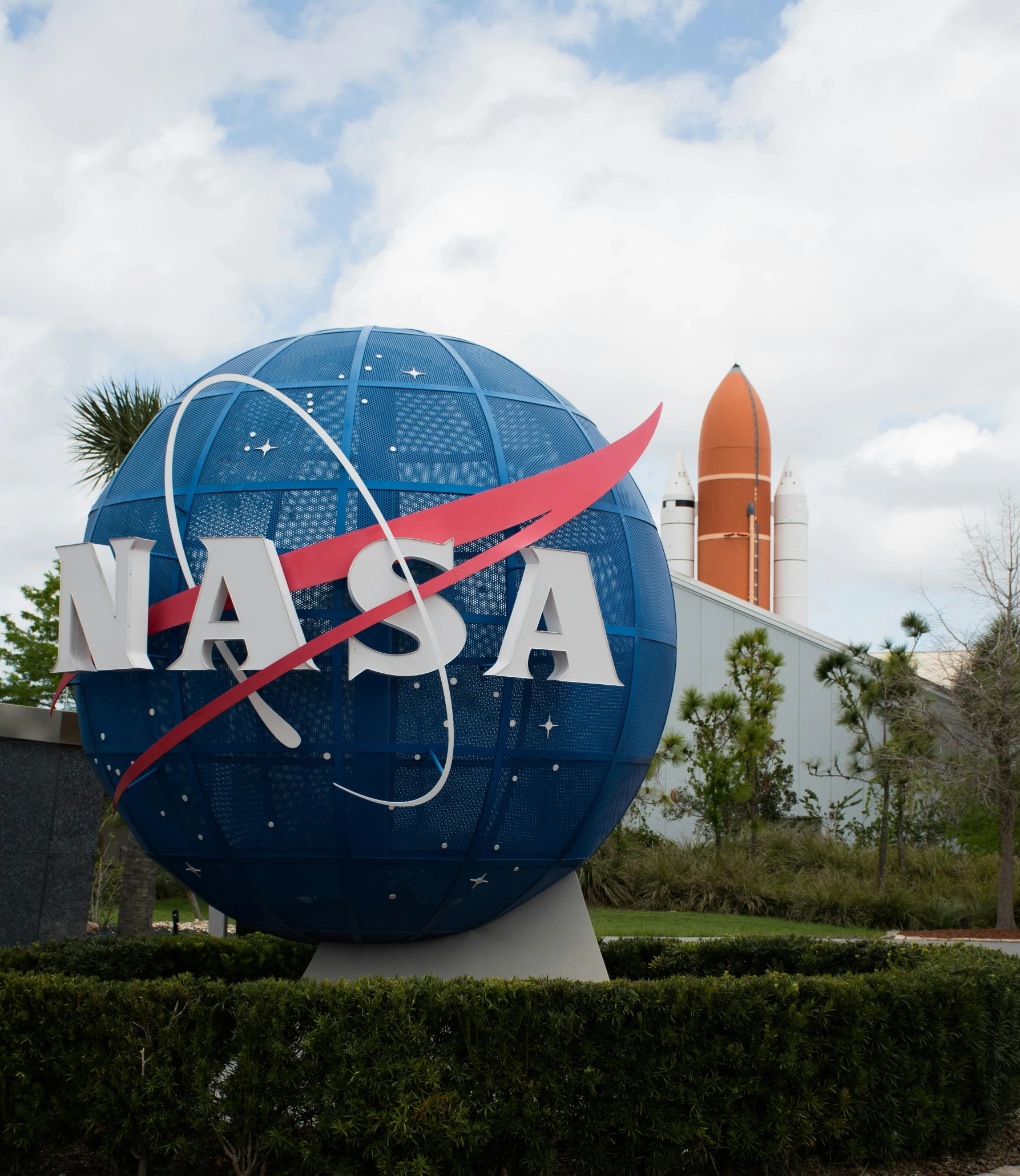 an odd view of nasa sign, with space shuttle in background