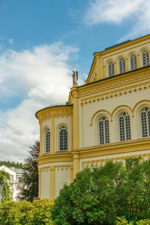 a yellow building that is by some trees