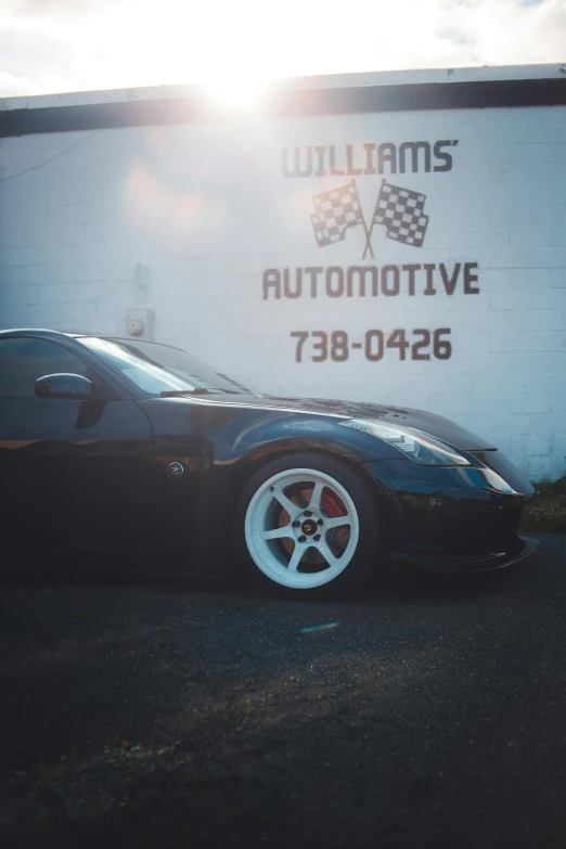 the black sports car is parked outside the garage