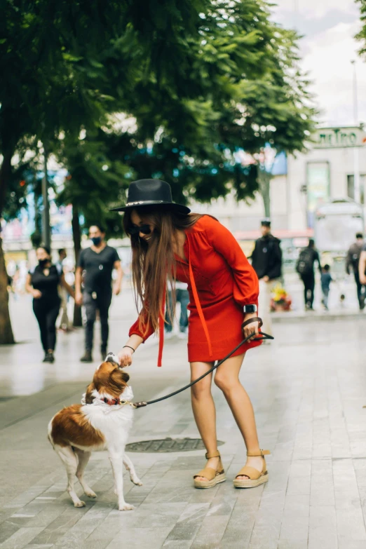 the woman and dog are outside on the sidewalk