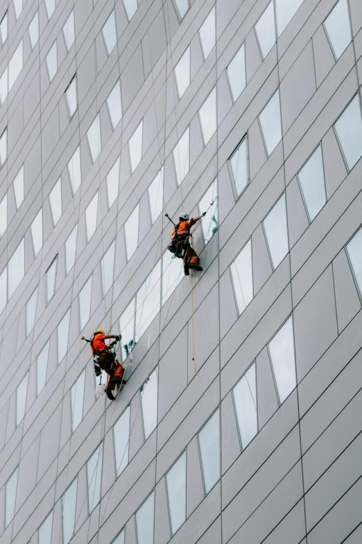 two people climbing up a very high building