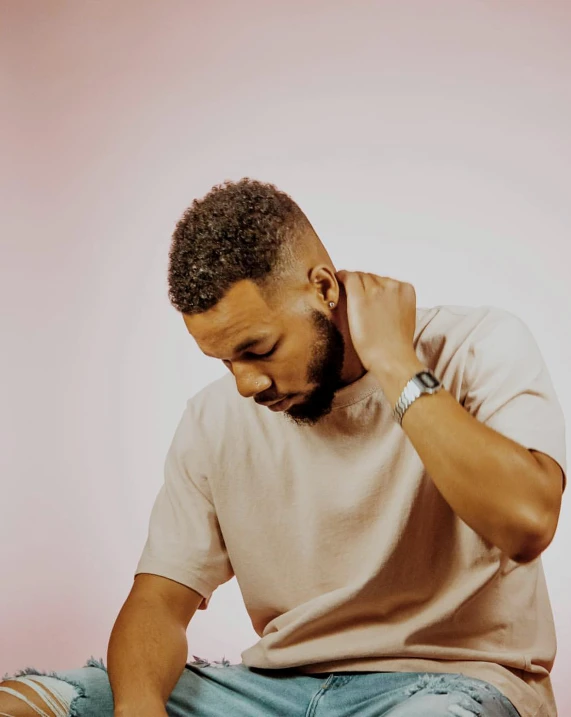 a man is sitting on the floor covering his ears