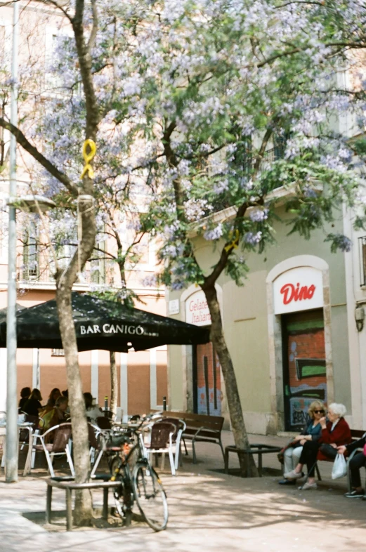 several people sitting on benches in the city