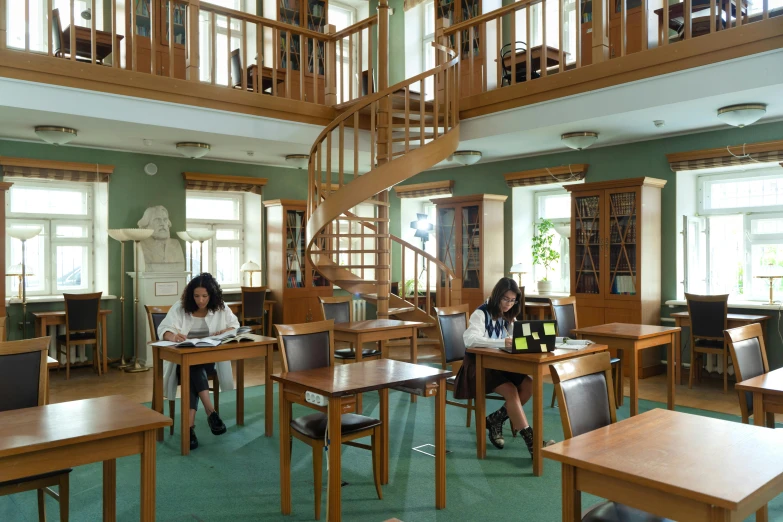 two students are reading books in the liry