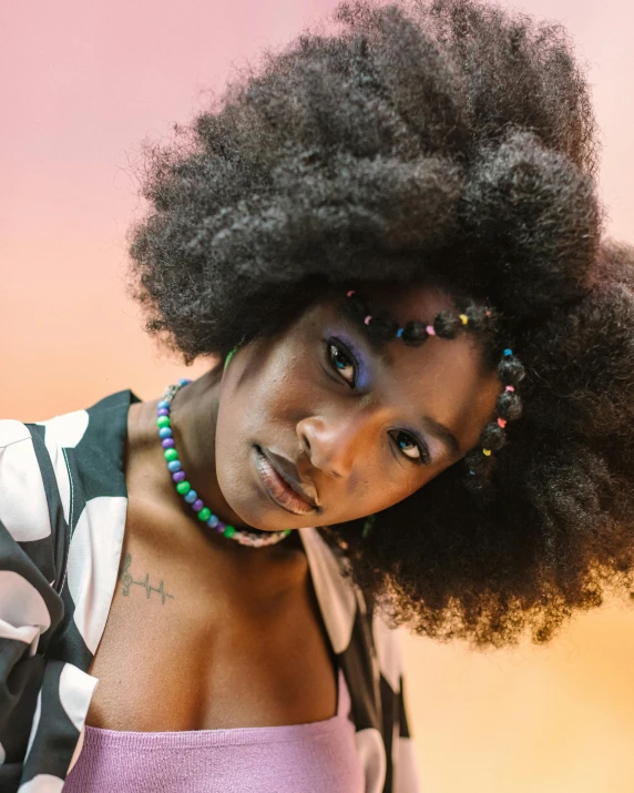 a woman with very large afros wearing a colorful top