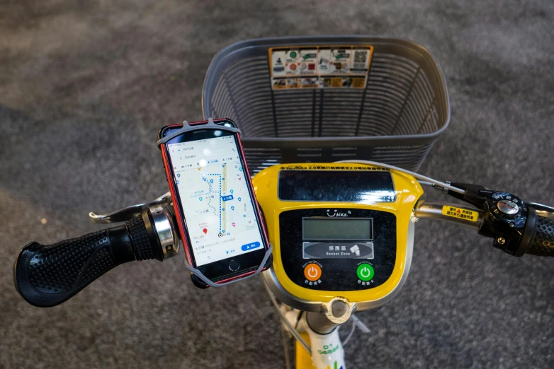 an iphone and an electronic device mounted to the front of a bike