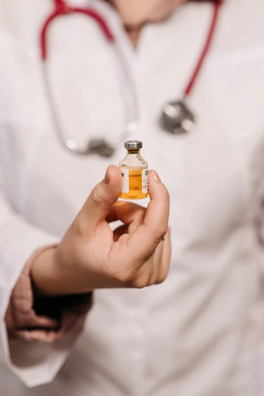 a female doctor holding a small bottle of perfume