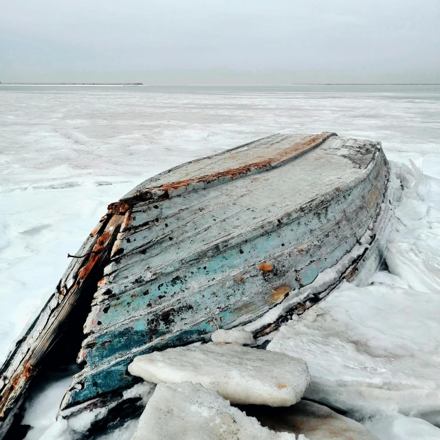 an old boat lies on ice in the middle of nowhere