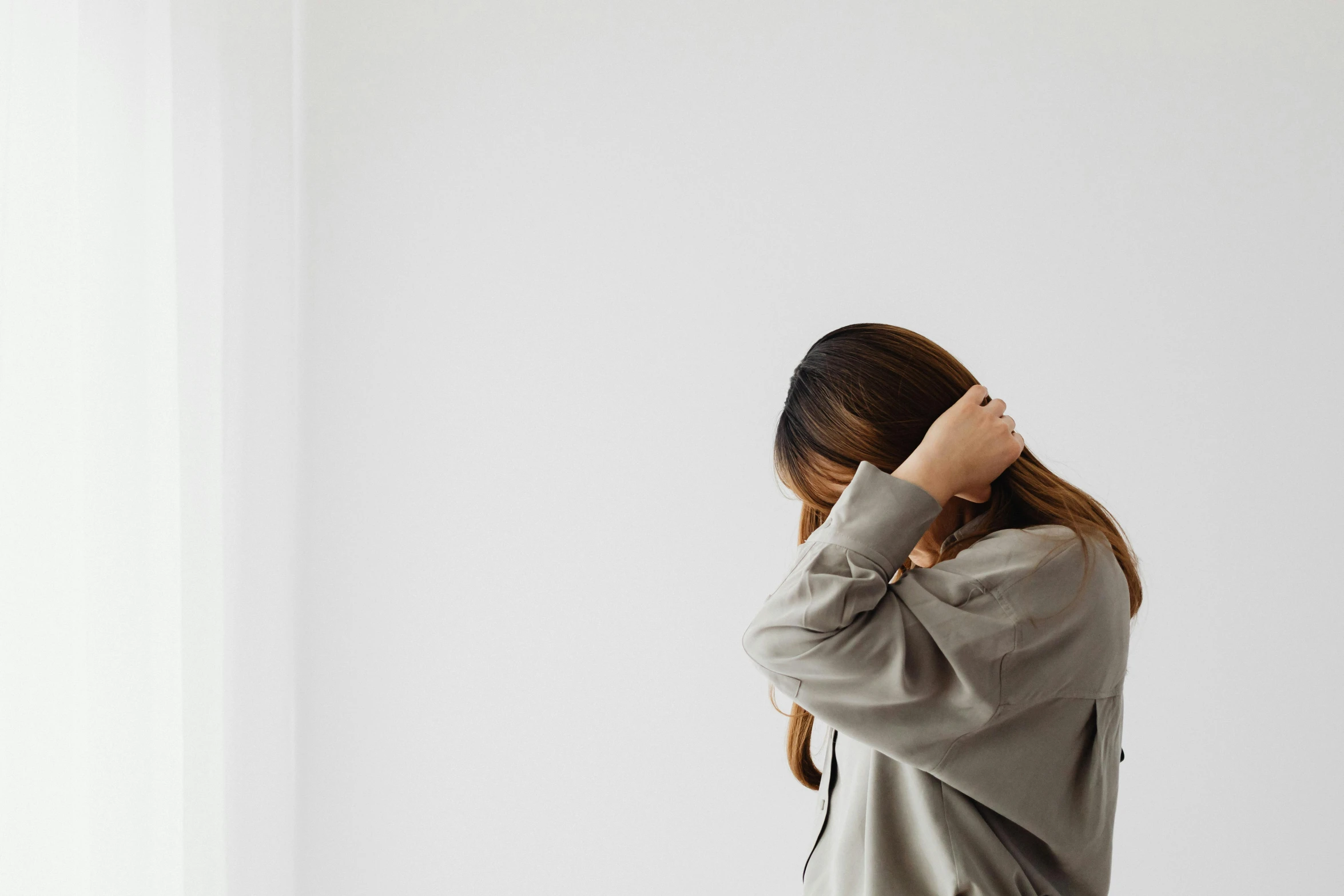 woman standing in an empty room with her hair pulled back