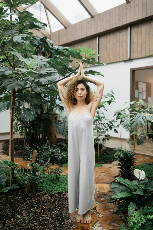 a woman in white is standing near trees