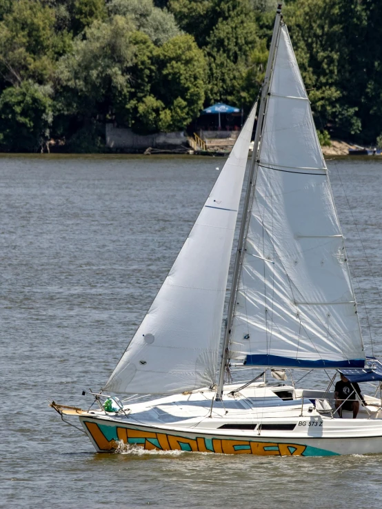 the sailboat with two masts is driving on the water