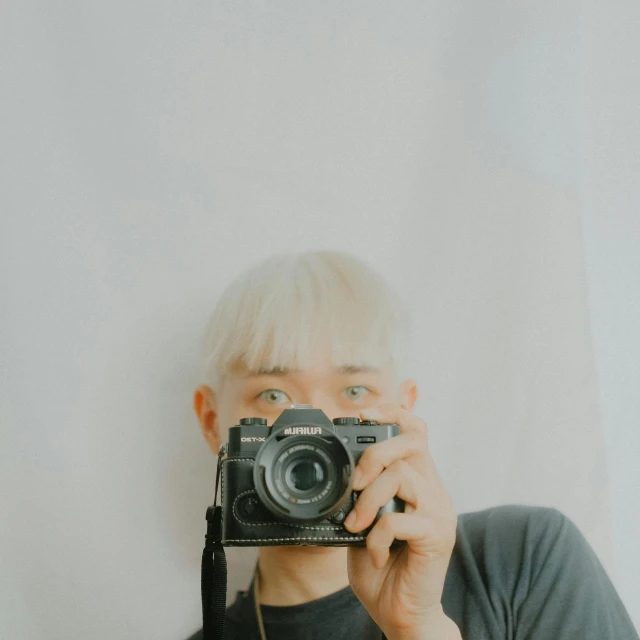 a woman with blond hair holding up a camera