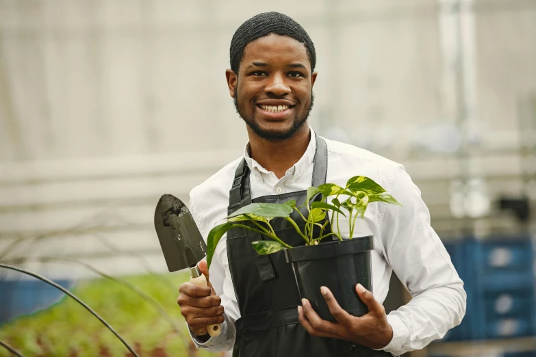 the man is holding a plant in his hands