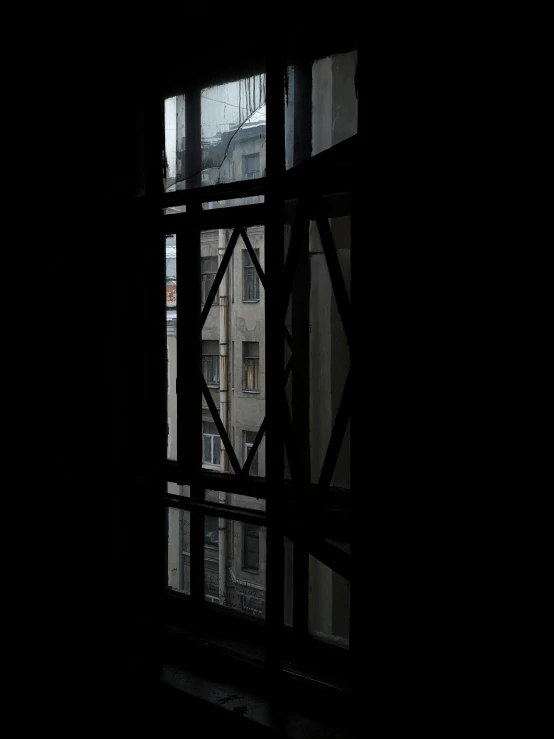 a dark room with lots of windows looking out at the city