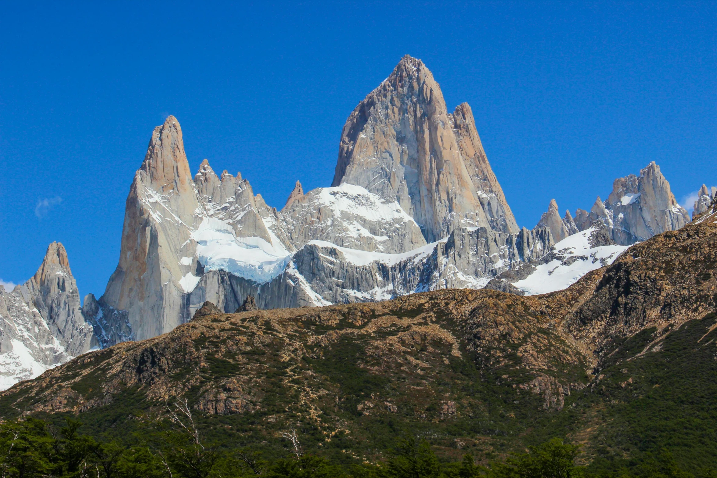 the view of three different snow - covered mountain ranges from a distance