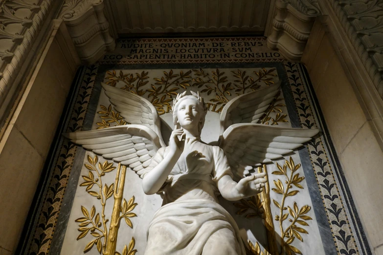 a white statue of a female angel in a wall