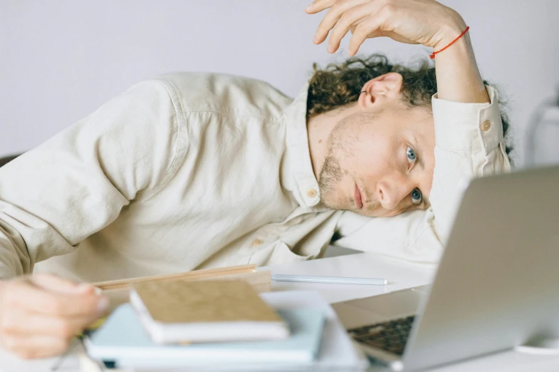 a man laying his head down on a desk