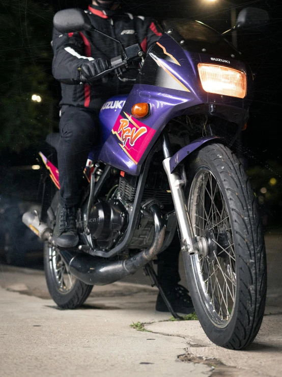 a man on a purple motorcycle riding on the road