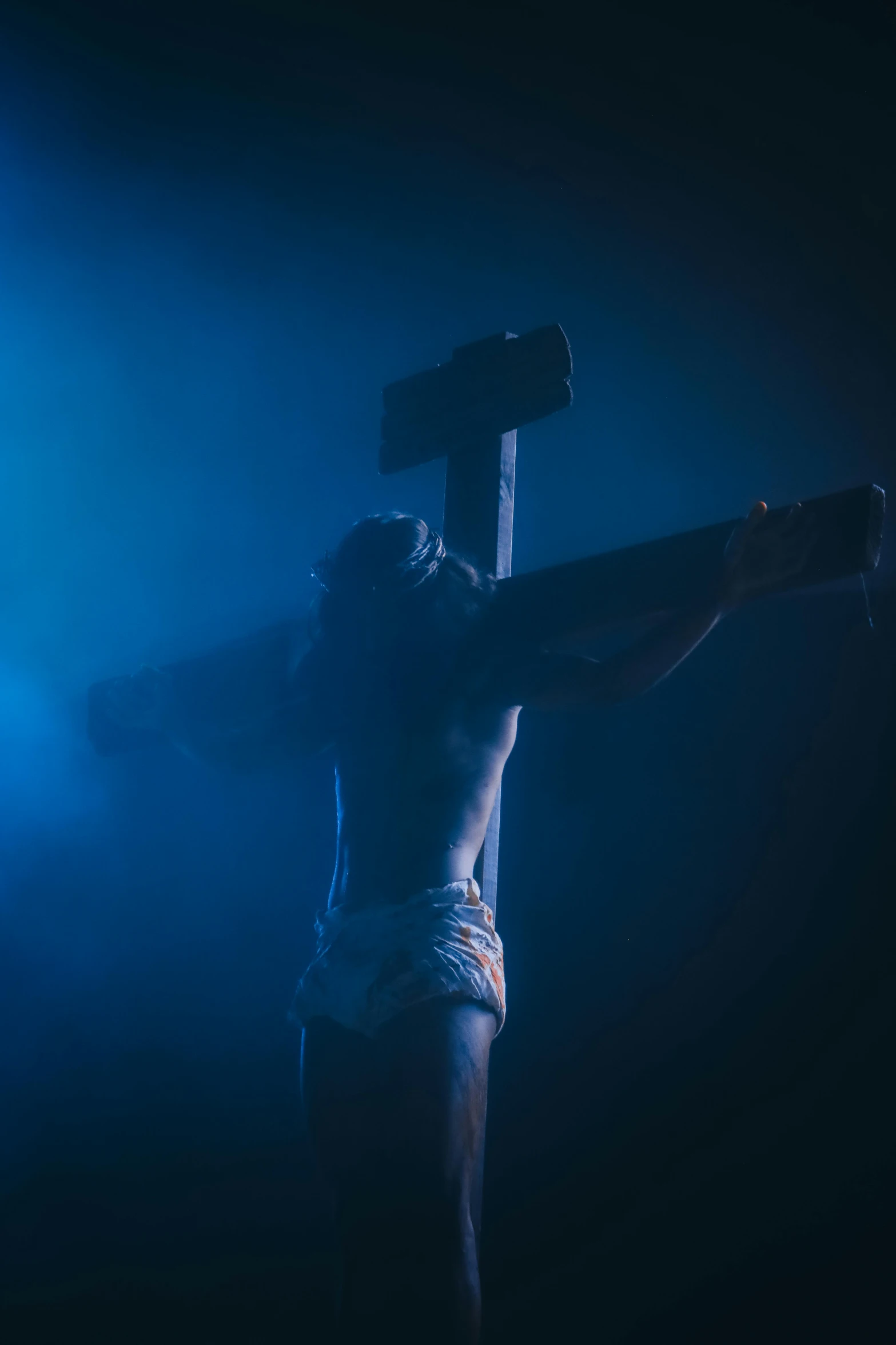 a person with  on, holding a cross and posing for the camera