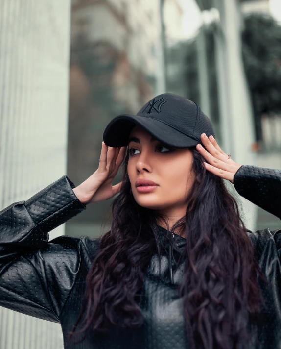 a woman posing for a po in a black hat