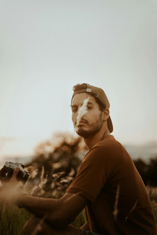 a man sits in the grass with a guitar