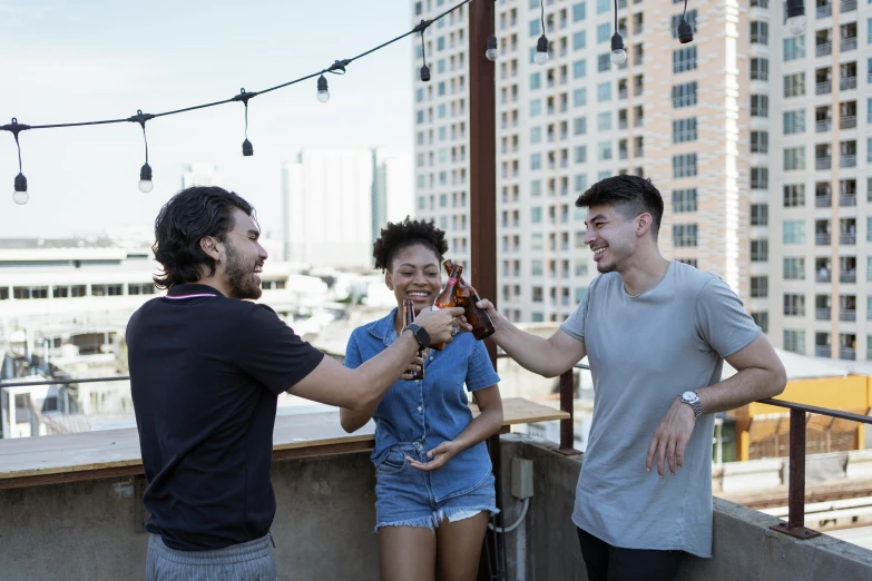 a group of young adults holding beer and talking