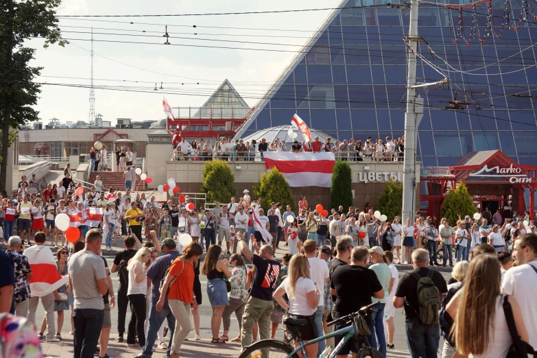 a large crowd of people standing outside in front of a building