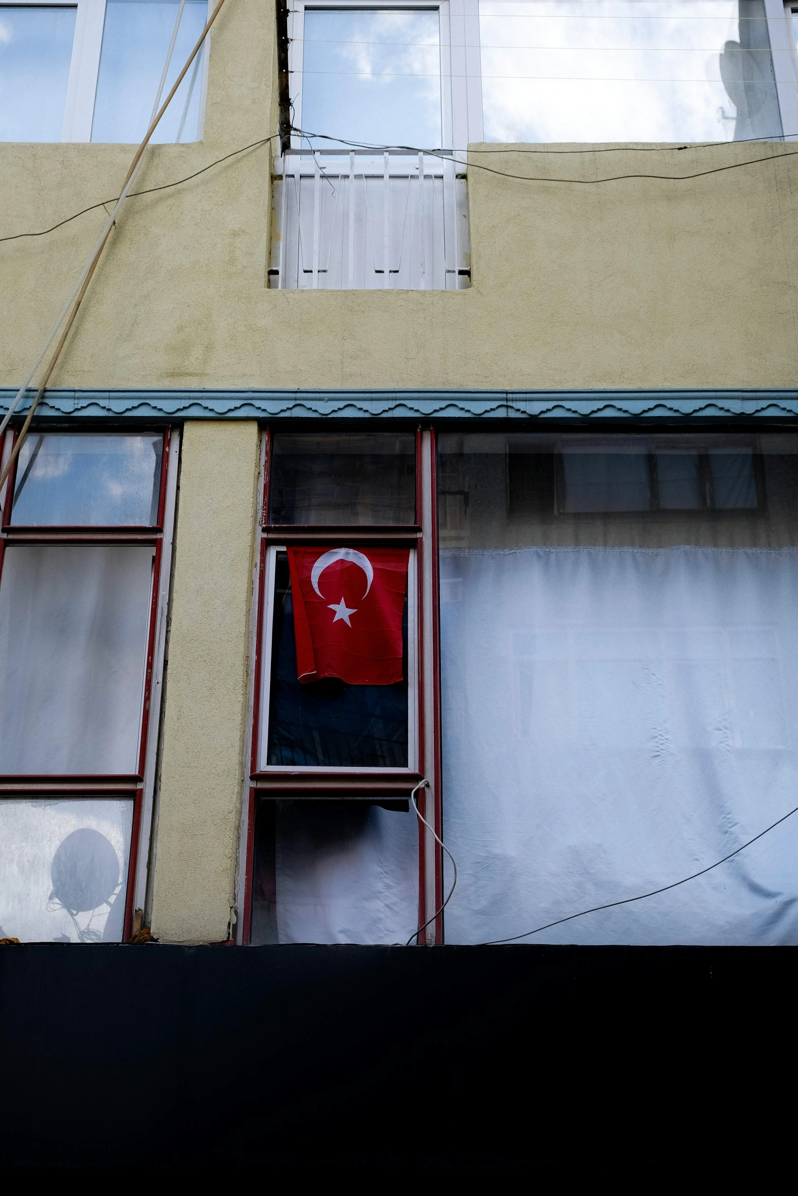 a small red flag stands in a window in a building