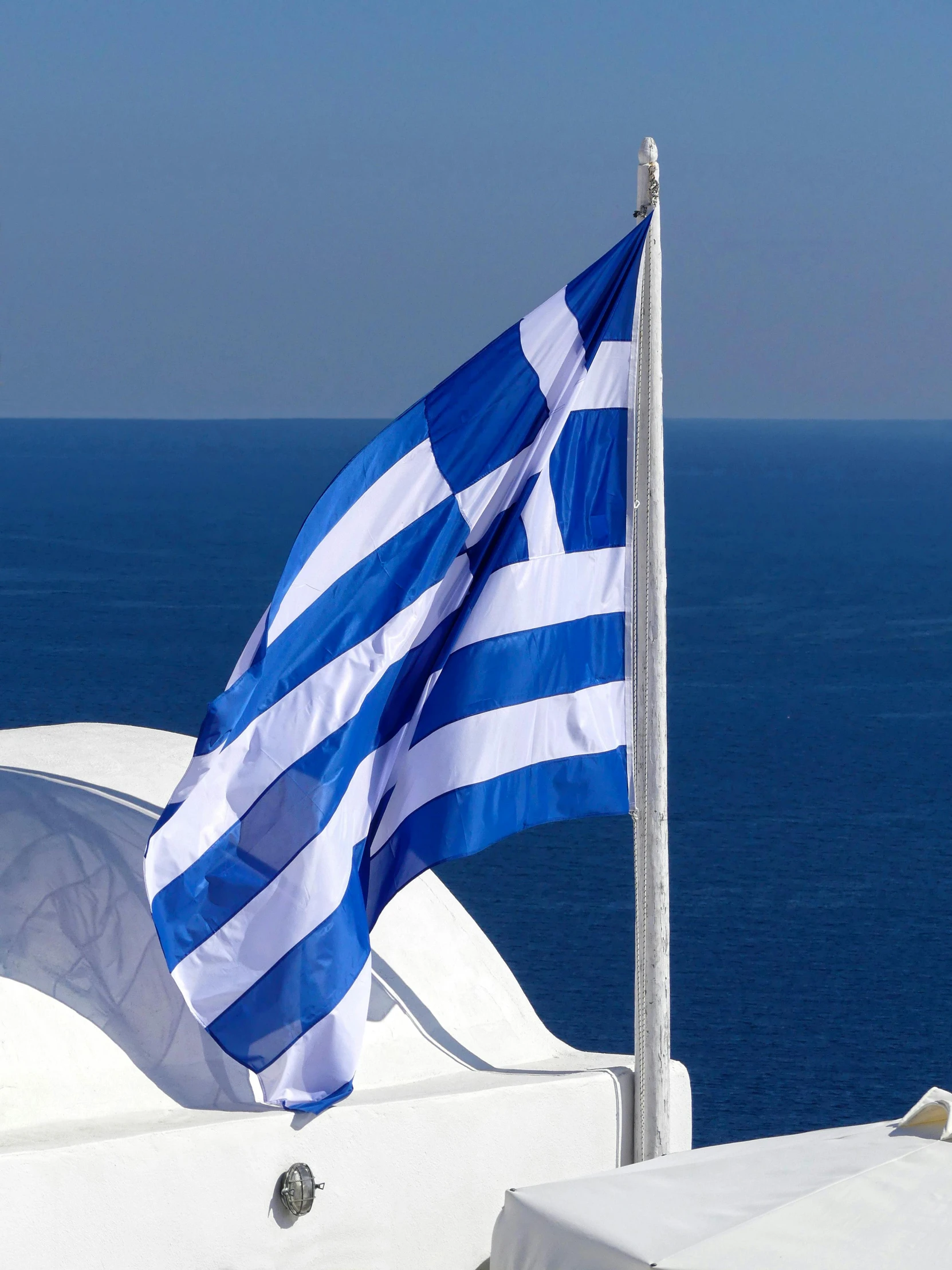 a greek flag is blowing in the wind