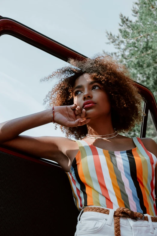 a woman posing in a car and leaning on a window