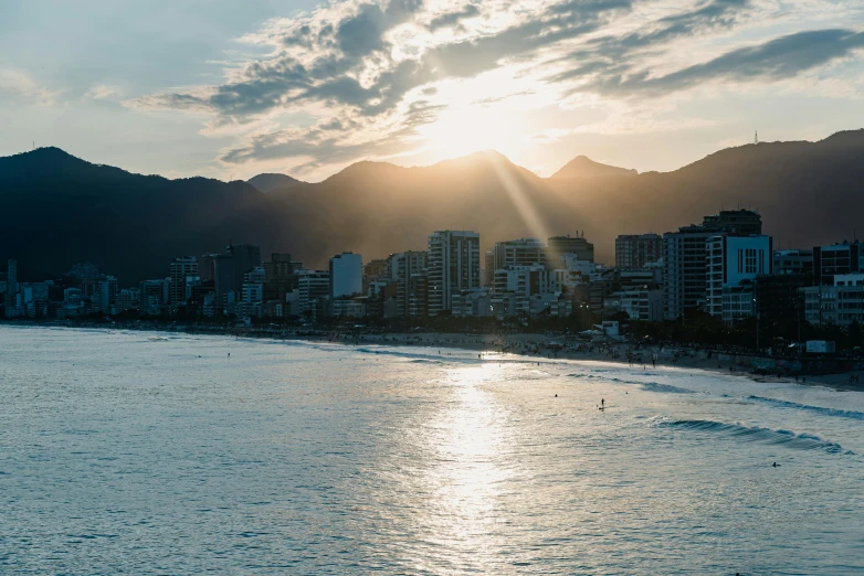 the sun sets over the city as it sits next to the water