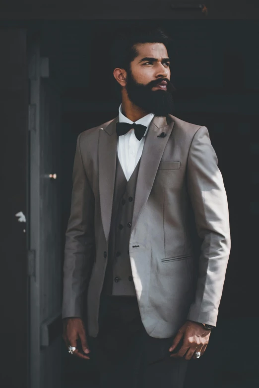 bearded man in suit and bow tie standing in doorway