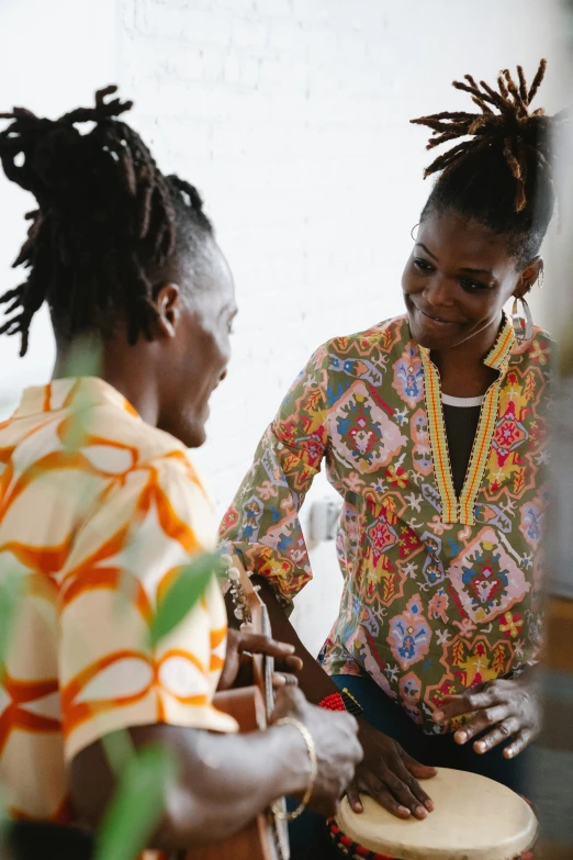 two women with dreadlocks are playing the drums