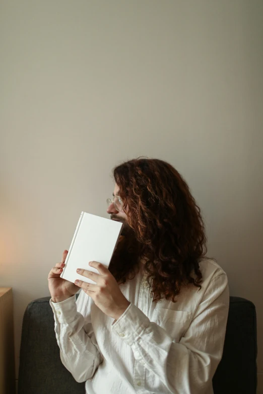 a woman holds a book and looks into the distance