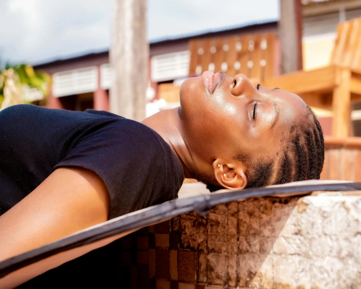 a boy wearing black laying on a wall