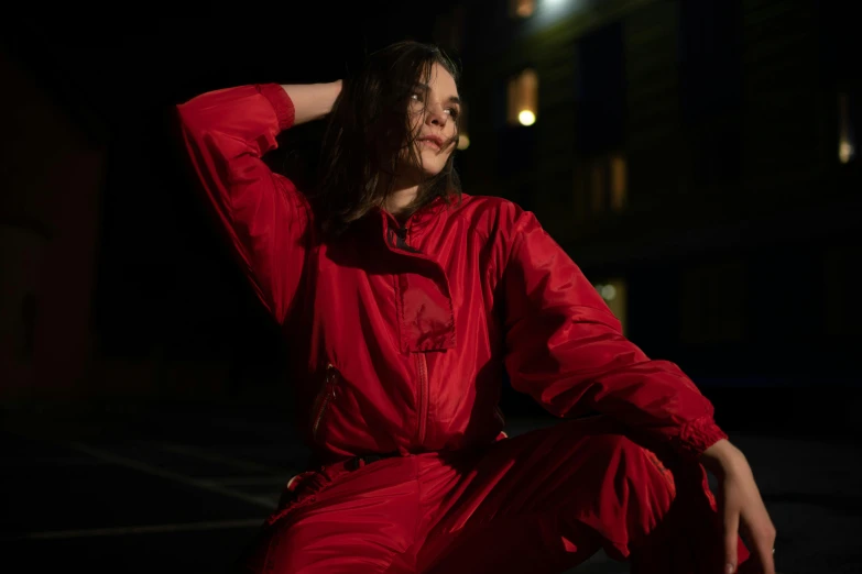 a woman sitting on the ground in a red outfit