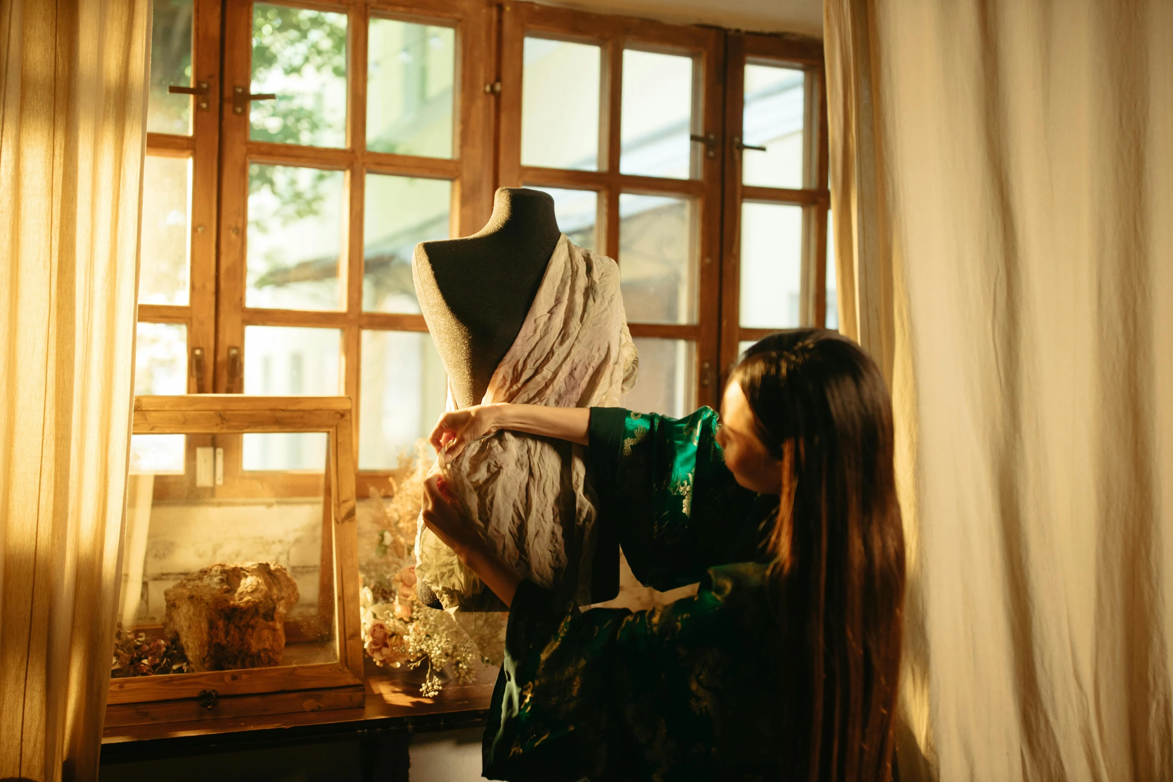 a woman wearing a dress in front of a window