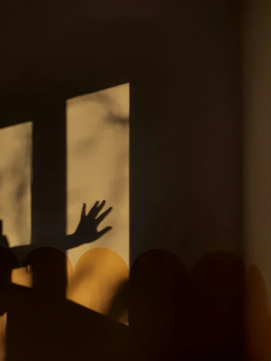 shadow of a hand being shown from a window