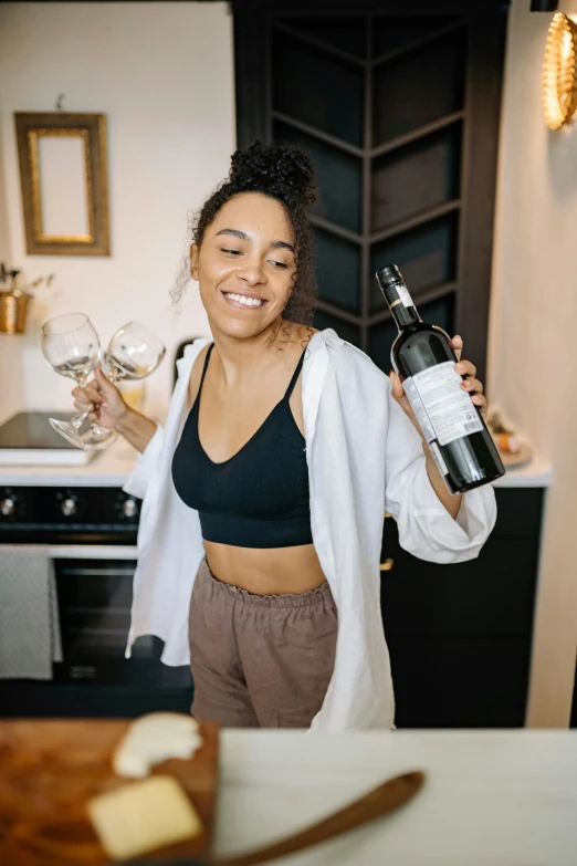 a woman holding a wine bottle in her hand and glasses